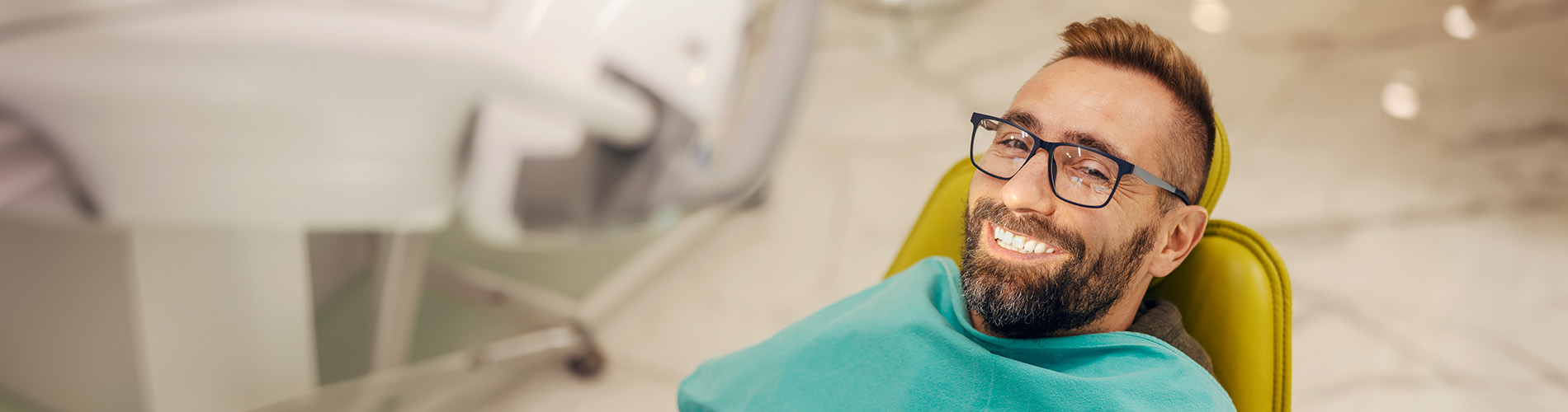 The image shows a modern dental clinic interior with various pieces of equipment, including a dental chair and an X-ray machine.